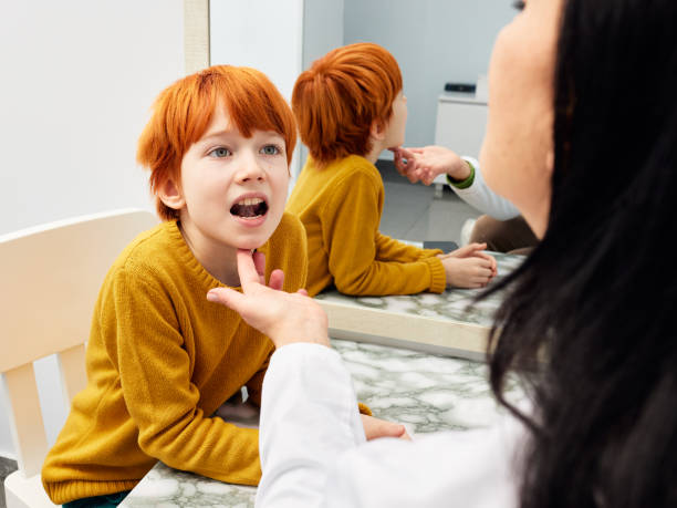 Enfant roux en séance d’orthophonie, observé par une professionnelle