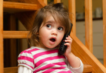 Petite fille parlant au téléphone avec expression surprise