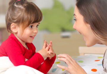 Enfant d’âge préscolaire en interaction verbale avec un adulte, illustrant une difficulté de langage possible